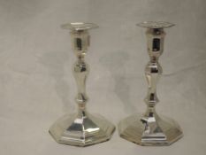 A pair of Edwardian silver candle sticks having removable sconces, shaped columns to stepped