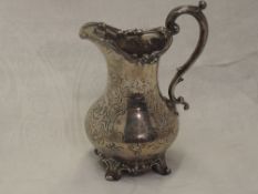 A Victorian silver jug of baluster form having engraved decoration with moulded loop handle and