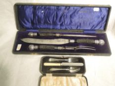 A cased three piece carving set having black antler handles with white metal finials, James