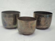 A pair of Victorian silver beakers having weighted bases, hammered decoration and bearing wedding