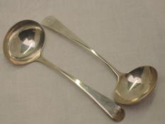 A pair of Georgian silver ladles of plain form bearing sun burst crest to terminals, London 1802,