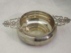 A Victorian silver porringer of plain circular form having decorative pierced handles and name