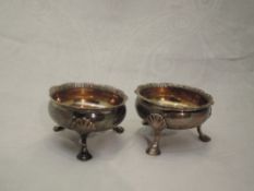 A matched pair of Georgian silver salts of circular form having trefoil hoof feet and frilled