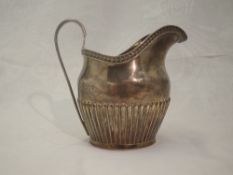 A Victorian silver cream jug of large form having gadrooned decoration to body, reeded loop handle