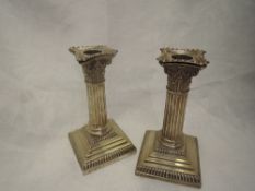 A pair of Edwardian silver candlesticks of Corinthian column form having removable sconces and