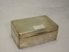 A silver cigarette box of rectangular form having engine turned stripe decoration and monogrammed