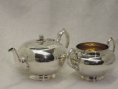 A Victorian silver teapot of plain compressed circular form having melon and leaf knop and