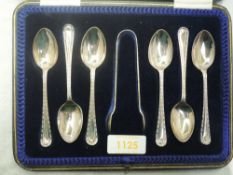 A cased set of six silver teaspoons with matching sugar nips having beaded decoration to stems and