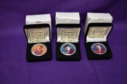 Three Morgan Mint Elvis Presley 2004 Silver Dollars in cases, each coloured on one side, each named,