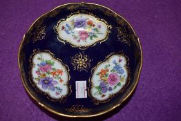 An antique pin dish having cobolt blue gold and hand decorated floral scenes bearing crossed