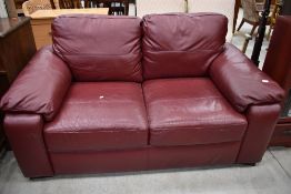 A modern burgundy leatherette two seater settee, width approx. 160cm
