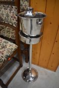 A chrome ice bucket on stand and cocktail shaker