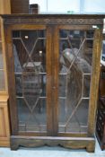 An early 20th Century oak astral glazed bookcase having blind fretwork frieze, width approx. 98cm,