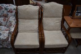 Two modern cane framed conservatory armchairs