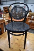 A traditional bentwood cane work chair, in black