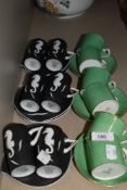 An assortment of coffee cups and saucers including green by Bishop and matte black with sea horse