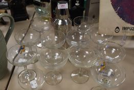 An assortment of glasses including Babysham and a cocktail shaker.