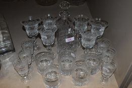 A shelf full of vintage Cumbria Crystal glasses, a decanter, and jug in the Grasmere design around