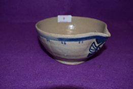An earthen ware spouted bowl having blue delft design having stamp to base possibly reading Poole