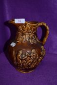 An earthen ware salt glazed jug having impressed scene