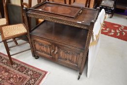 An oak tea trolley having under cupboard