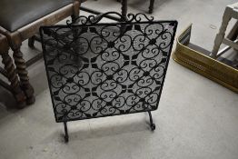 A wrought iron and wirework fire guard/screen