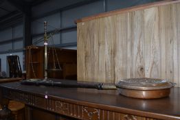 A traditional embossed copper warming pan and a set of brass balance scales