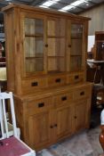 A top quality modern solid golden oak dresser, having open shelves flanked by displays over three