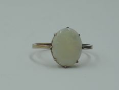 A lady's dress ring having an oval opal in a claw set mount on a rose gold loop tested as 9ct