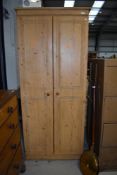 A modern pine wardrobe having carved double doors W73cm x H180cm x D51cm