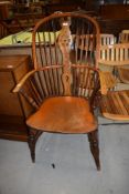 A traditional antique elm seated and steamed ash bow back Windsor chair having wheeled vase back