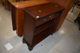 A reproduction dark stained hard wood book shelf and drawer unit