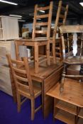 A modern pine full length drop leaf table and set of four solid seat ladderback chairs