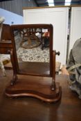 A toilet mirror having tilting mahogany frame