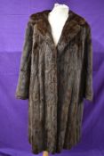 A vintage mid length brown fur coat.