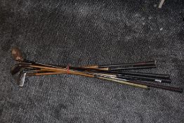 A selection of early sporting hickory shafted golf clubs including Mashie Niblick