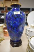 A Cloisonné vase in blue hues having floral design with chrysanthemums on wooden stand.