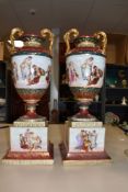 A large pair of impressive urns, thought to be Royal Vienna having heavy and ornate gilt detailing
