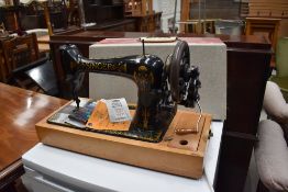 A vintage hand cranked Singer sewing machine , numbered V970941, in later case, with accesories