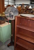 A Victorian mahogany and brass pole screen, having two circular oil paintings on canvas, each