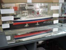 A wooden scratch built model of the QE2 Cruise Ship operated by Cunard, on stand in glass case, (