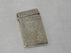 A silver card case having hinged lid, extensive scroll decoration and monogrammed cartouche,