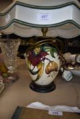 A Moorcroft Anna lily table lamp with shade having lily design in green,red and ochre on cream