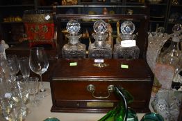 A mid century tantalus with a set of Stuart decanters and two HM silver name tage one for port and