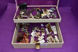 A jewellery box containing a selection of costume jewellery including clip and stud earrings, native