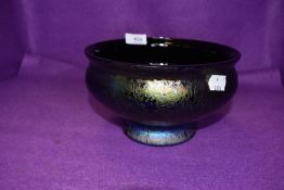 An lustre glass bowl having footed base and small chip to rim