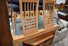 A modern beech effect extending dining table having frosted effect glass top and a set of four