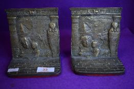 A pair of brass cast Egyptian book ends with pyramid and sarcophagus decoration