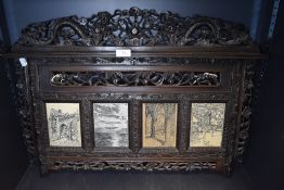 An ornately carved antique wall mounted picture/photo frame having oriental styling.