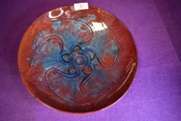 A Pilkingtons Royal Lancastrian charger having blue and red ground with abstract floral pattern to